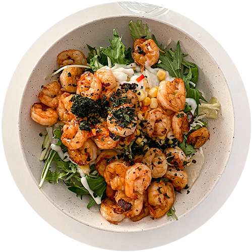 A bowl of shrimp and vegetables on a white plate.