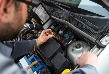 man working on a cars electrical system