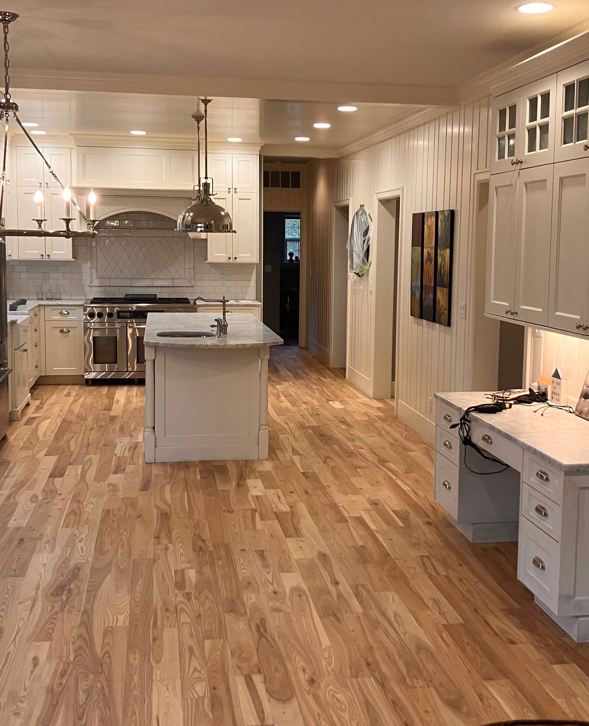 Kitchen with navy blue cabinets, stainless steel appliances, white countertops, and hardwood floors.