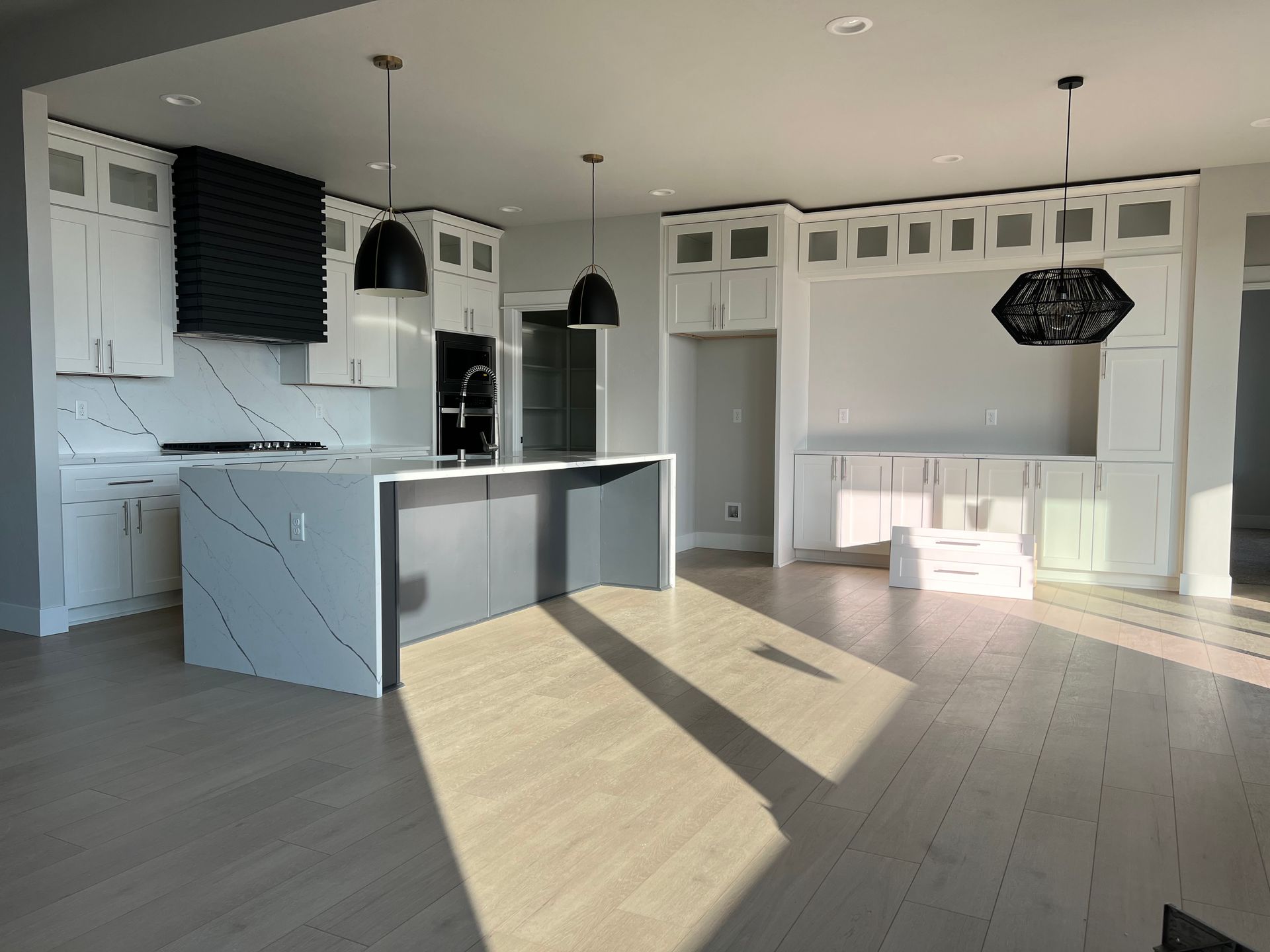 Luxurious living room with a large fireplace and chandelier, featuring a stone countertop in the foreground.