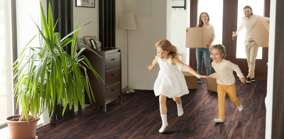 woman moving box siblings running
