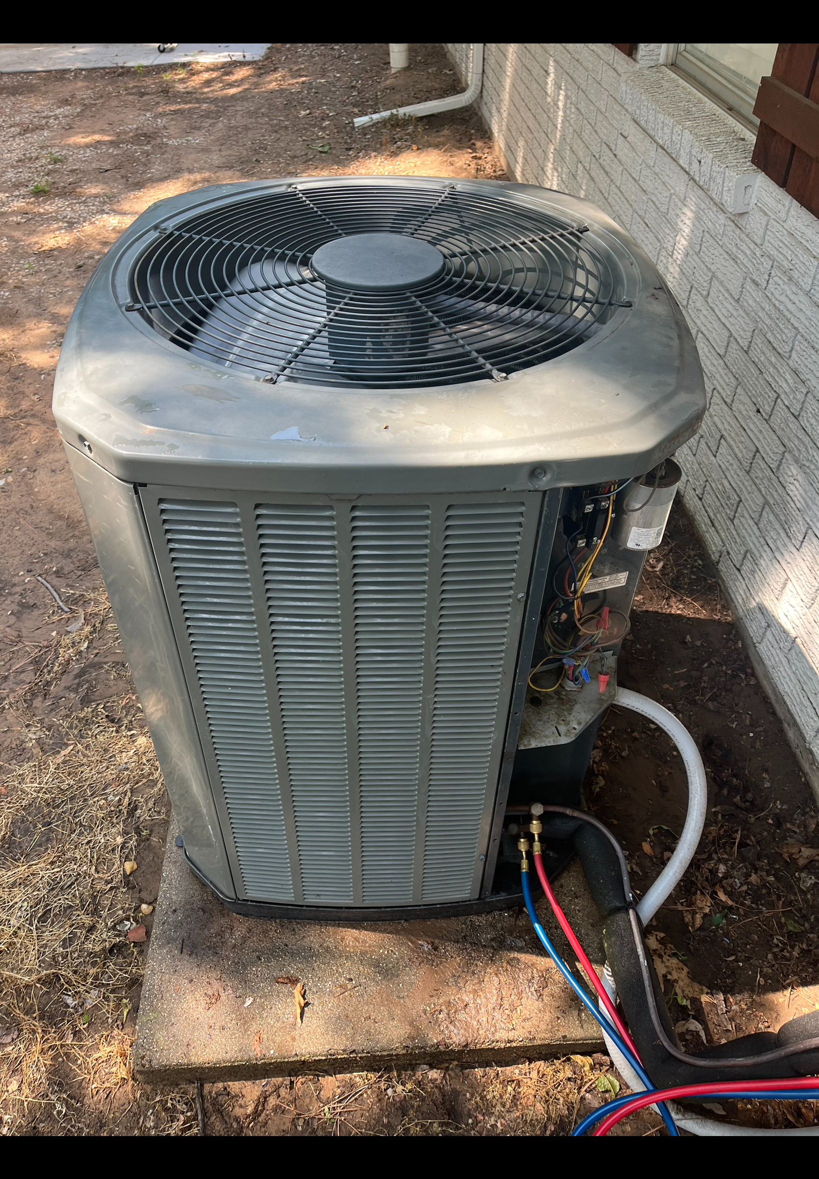 A large air conditioner is sitting on the side of a building.