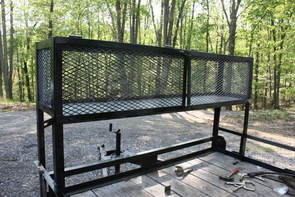 A metal cage is sitting on top of a wooden table in the woods.