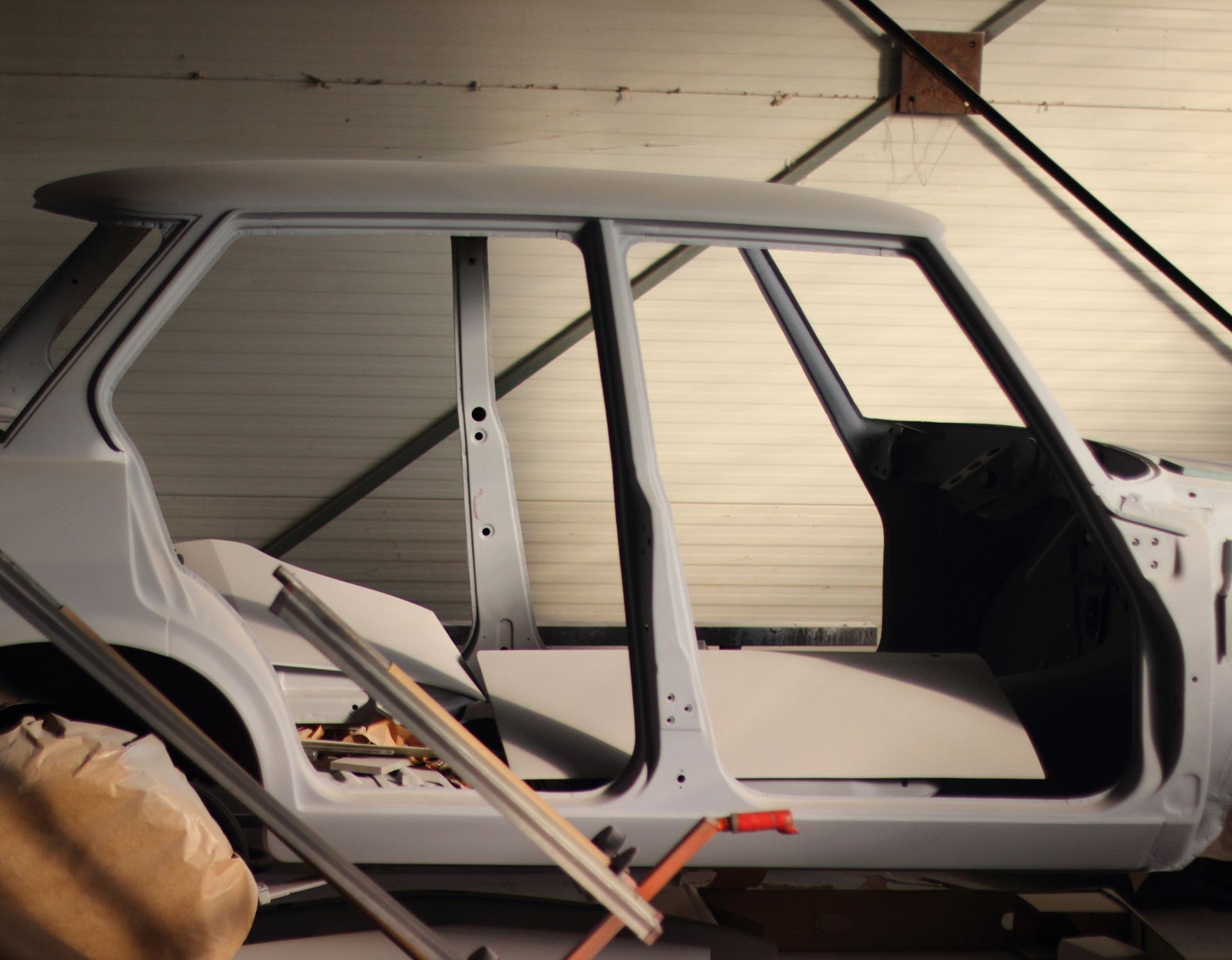 A white car is sitting in a garage with the door open