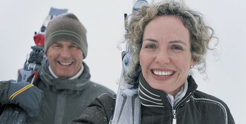 Skiing couple with dentures smiling