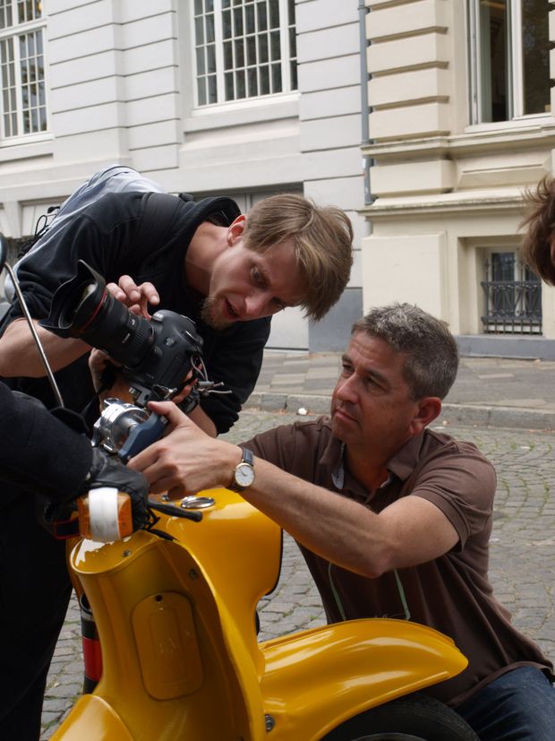Kameramann und Student richten Kamera an Moped ein für Abschlussfilm