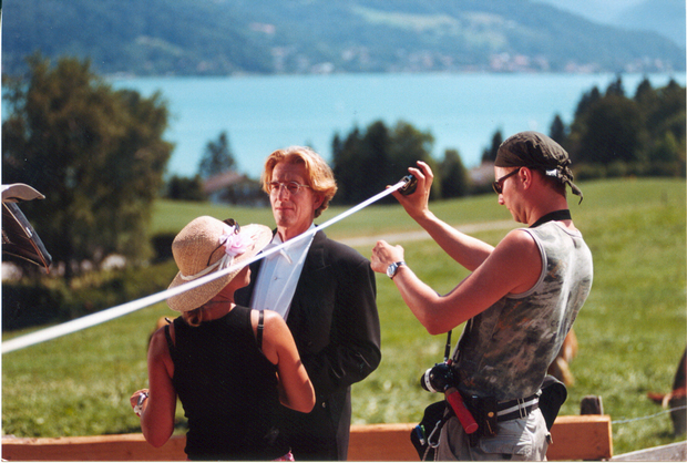 Kameraassistent misst Entfernung zu Darsteller vor Kulisse Tegernsee für Werbefilmdreh