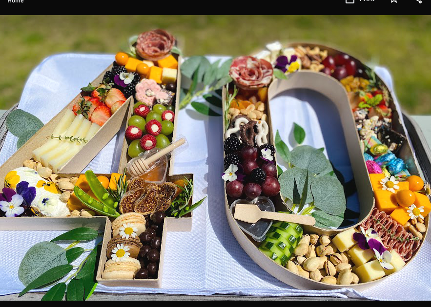Charcuterie board arranged in the shape of the number 40, filled with various cheeses, fruits, and snacks.