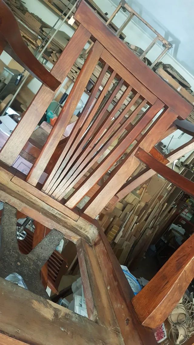 Una sedia a dondolo di legno è appoggiata su un tavolo in una stanza.