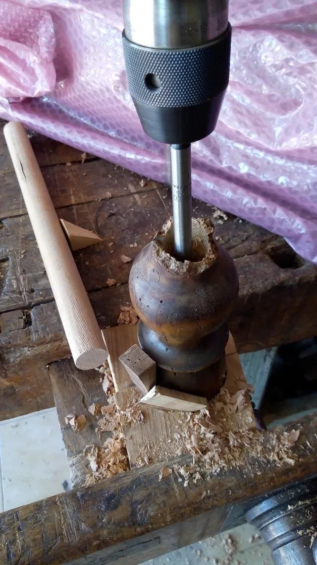 Si sta utilizzando un trapano per fare un foro in un pezzo di legno.