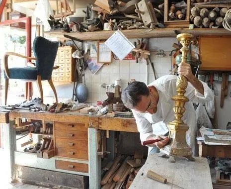 Un uomo sta lavorando a un portacandele in un laboratorio.