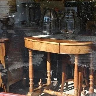 Un tavolo di legno è posto davanti a una finestra di vetro.