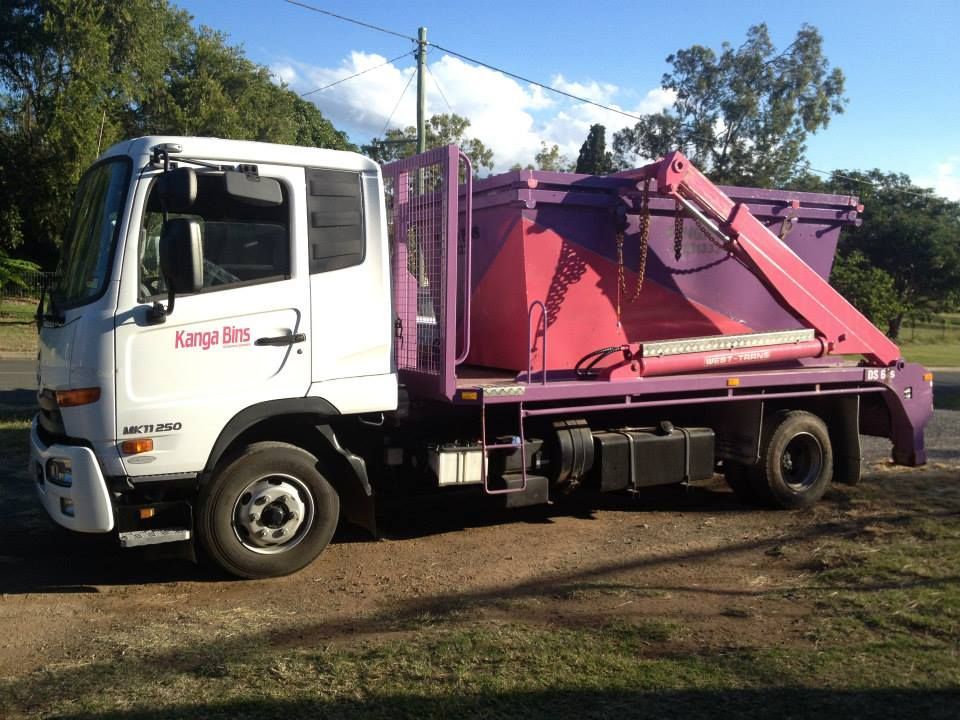 White Truck With A Pink Dumpster On The Back Parked On The Side Of The Road — Kanga Bins Qld Pty Ltd In Mulara, QLD
