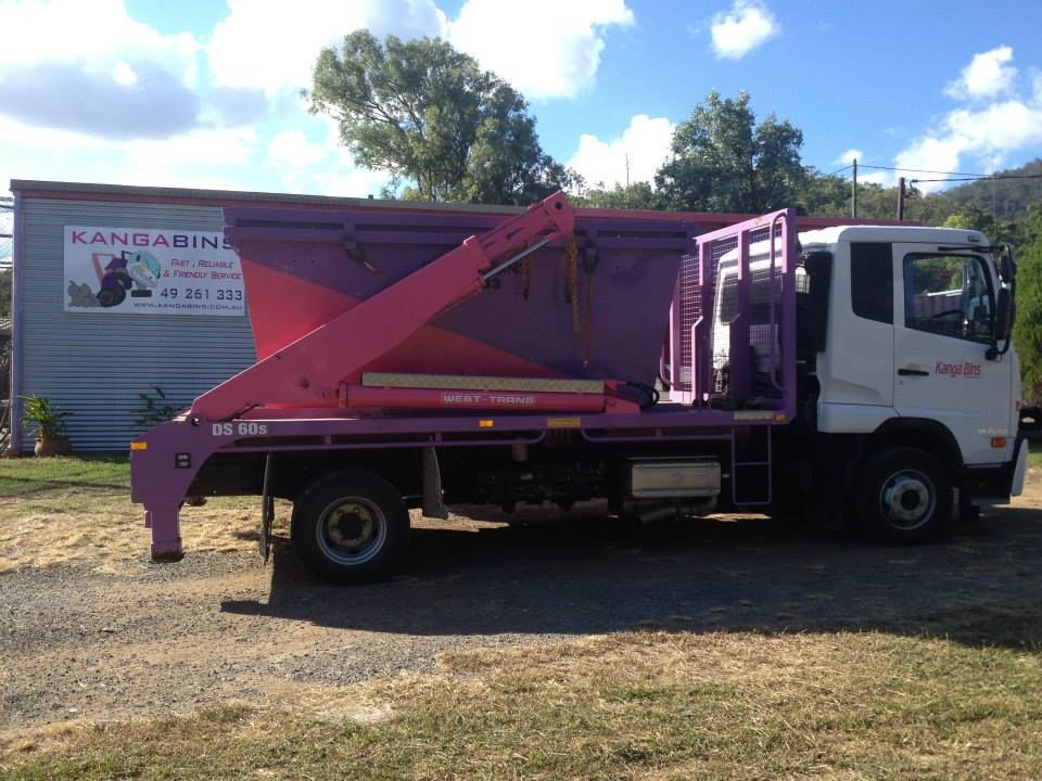 Purple Dump Truck Parked In Front Of A Building — Kanga Bins Qld Pty Ltd In Mulara, QLD