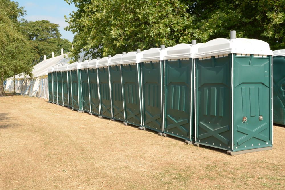 Row Of Green Portable Toilets Lined Up In A Field — Kanga Bins Qld Pty Ltd In Mulara, QLD