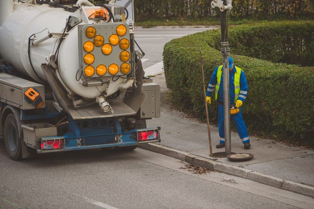 Man Standing Next To A Vacuum Truck On The Side Of The Road — Kanga Bins Qld Pty Ltd In Mulara, QLD