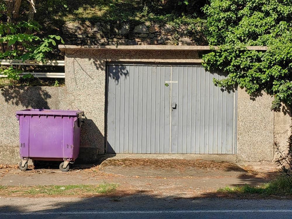 Purple Dumpster In Front Of A Garage Door — Kanga Bins Qld Pty Ltd In Mulara, QLD
