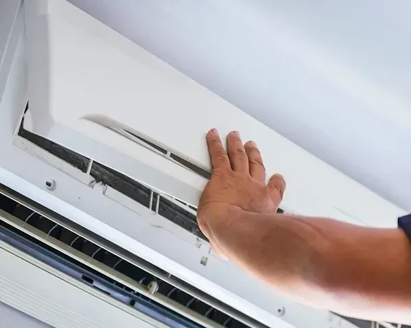 Repair technician adjusts a ductless AC unit