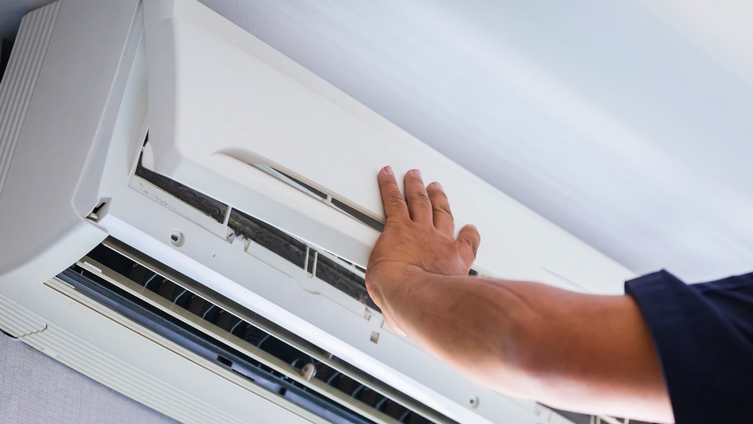 Repair technician adjusts a ductless AC unit