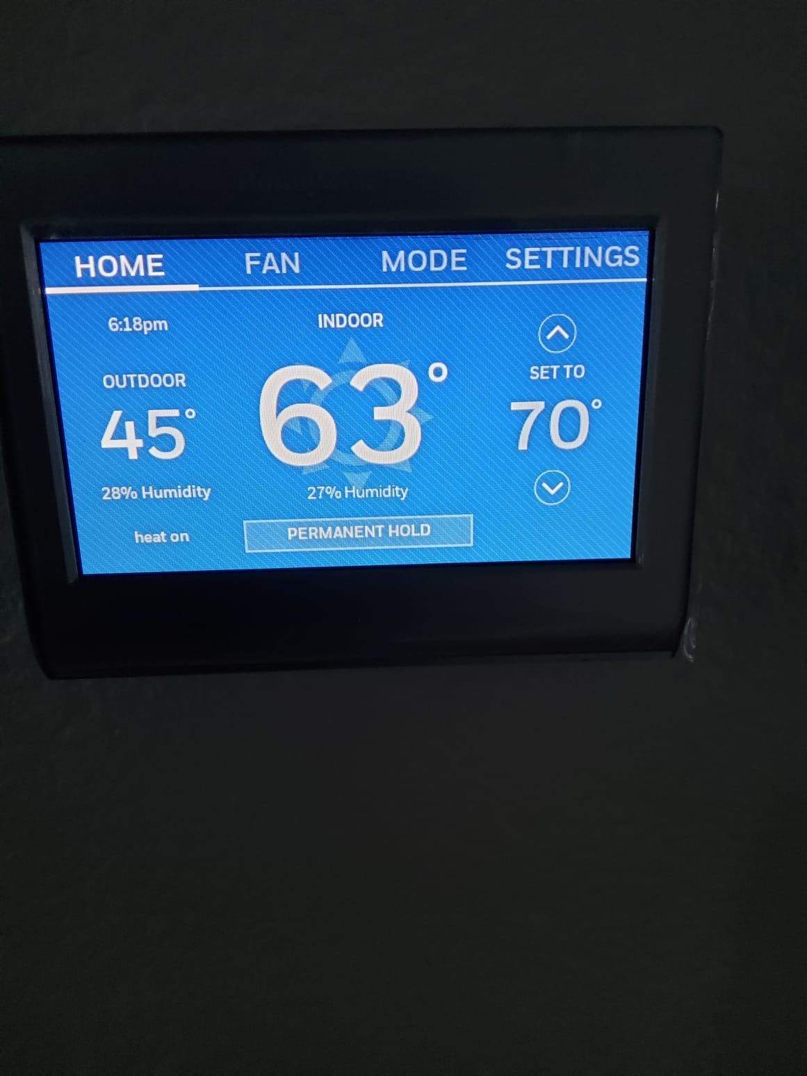 Thermostat screen displaying an indoor temperature of 63°F, set to 70°F, outdoor temperature 45°F.