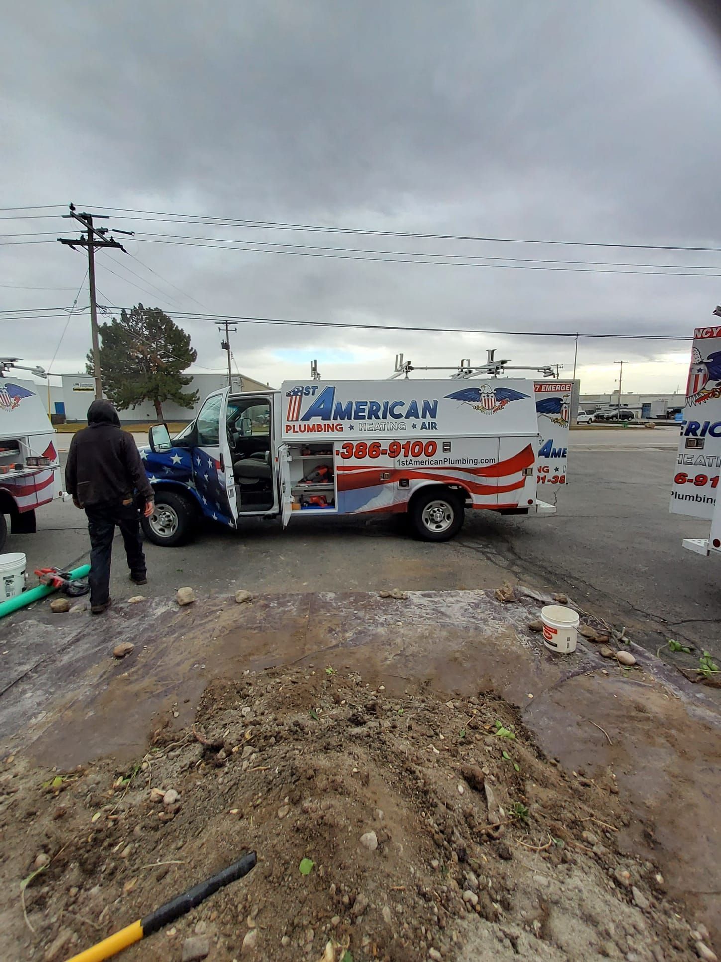 A man stands near a work truck, marked with