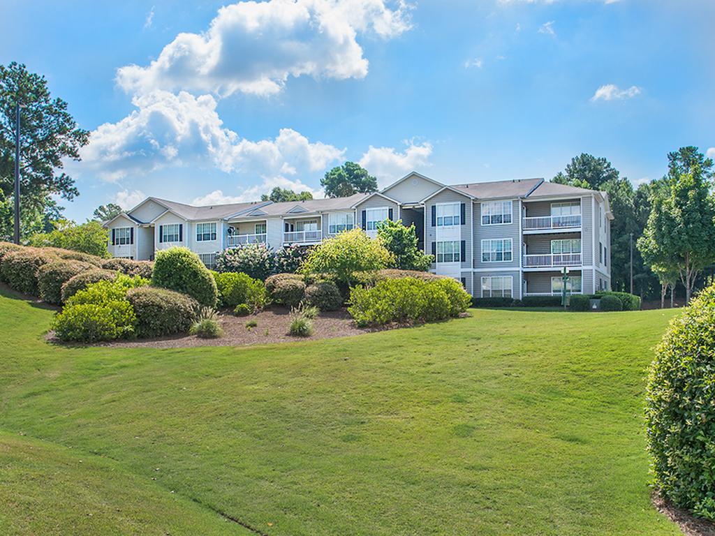 A large apartment building with a lush green lawn in front of it at Lake St. James.