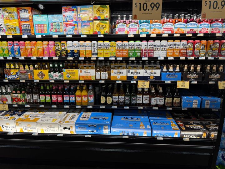 A shelf in a grocery store filled with bottles of soda.