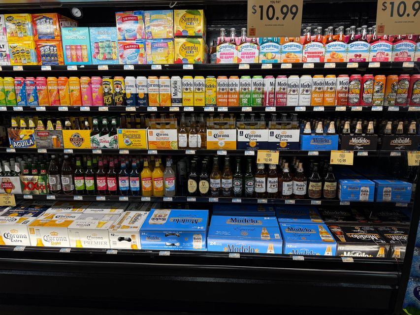 A shelf in a grocery store filled with bottles of soda.