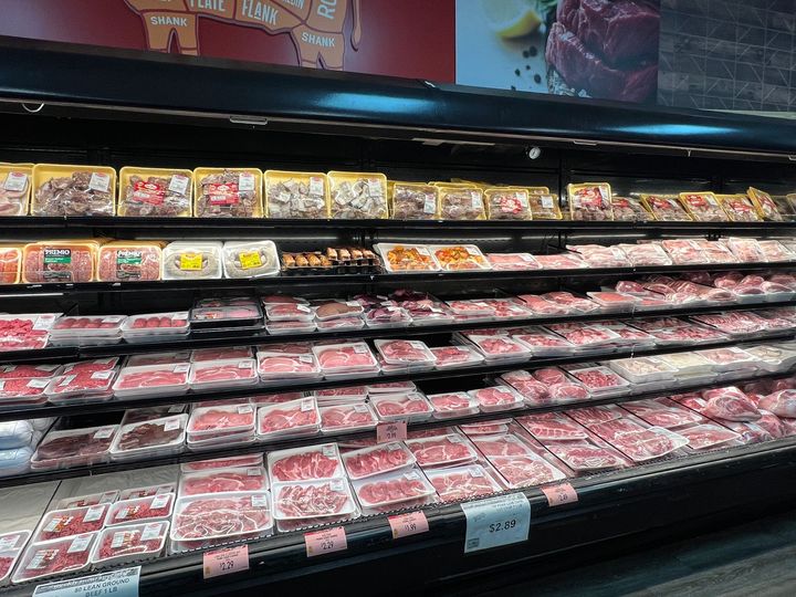 A variety of meats are on display in a butcher shop