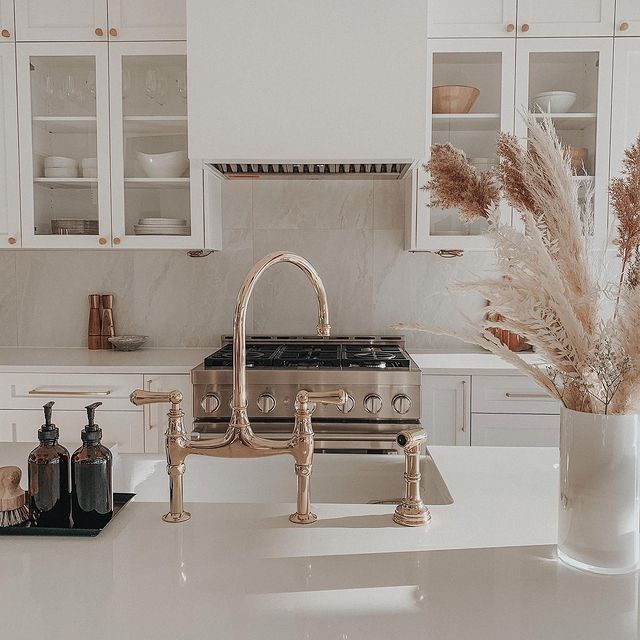A kitchen with a stove , sink , and faucet.