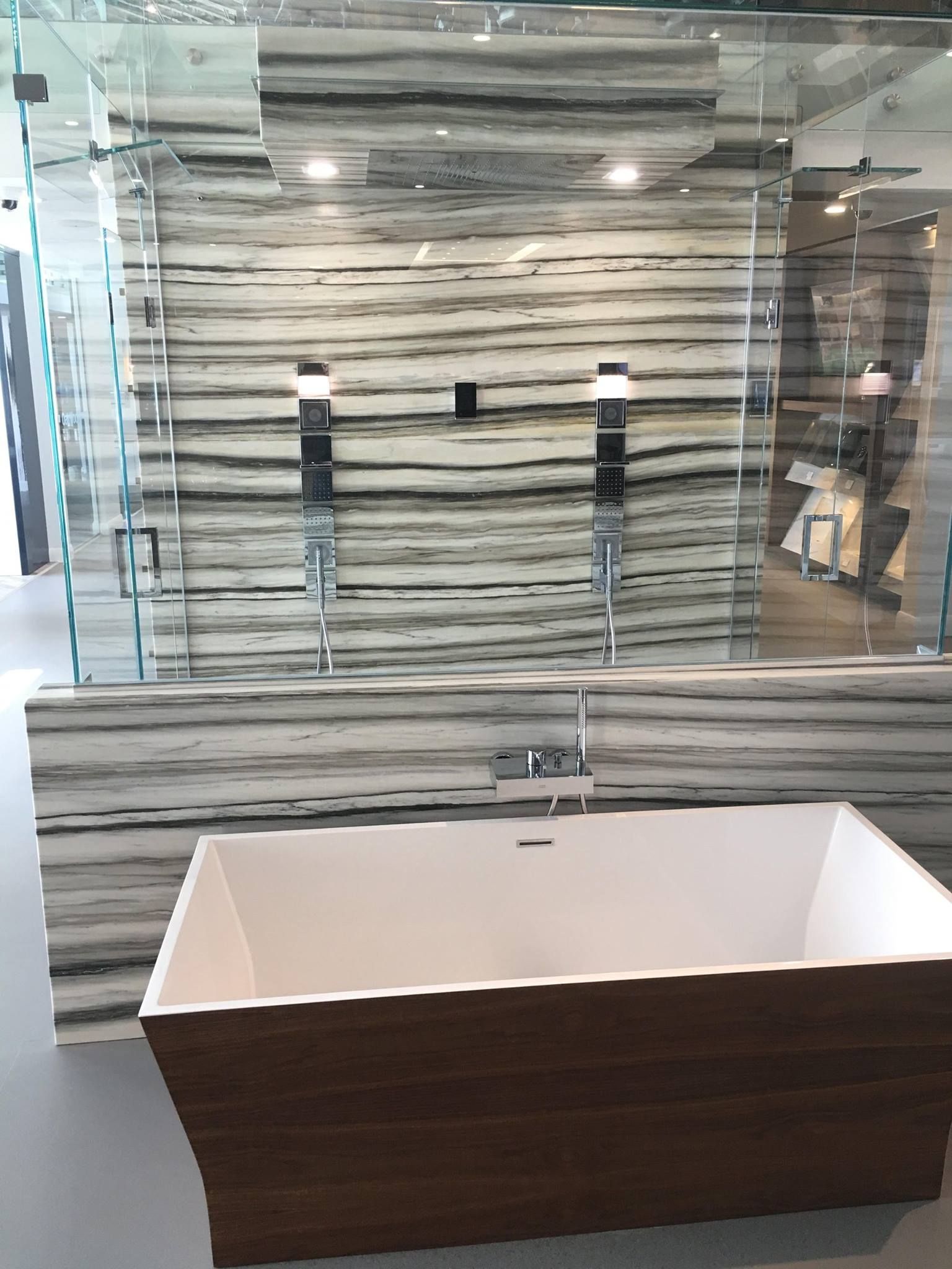 A bathtub is sitting in a bathroom next to a shower stall.