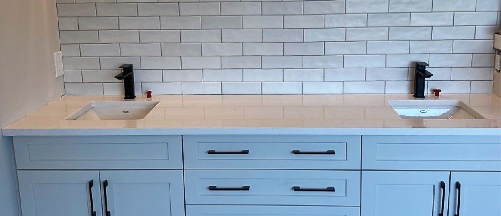 A bathroom with two sinks and a brick wall.