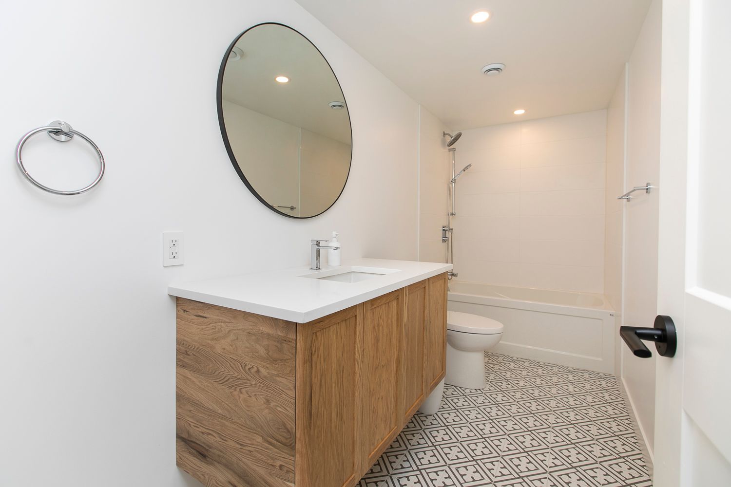 A bathroom with a toilet , sink , mirror and bathtub.