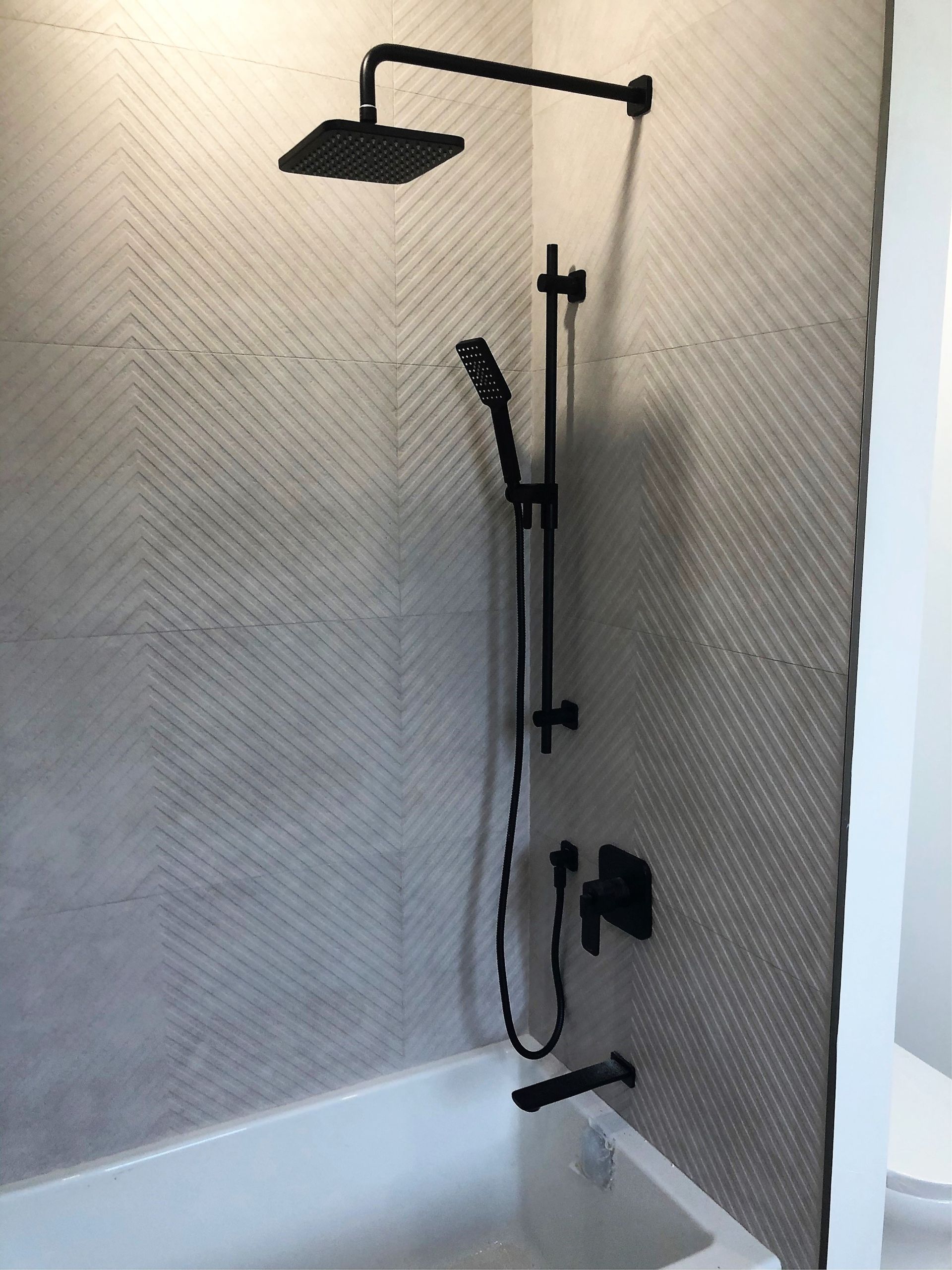 A bathroom with a shower head and a bathtub