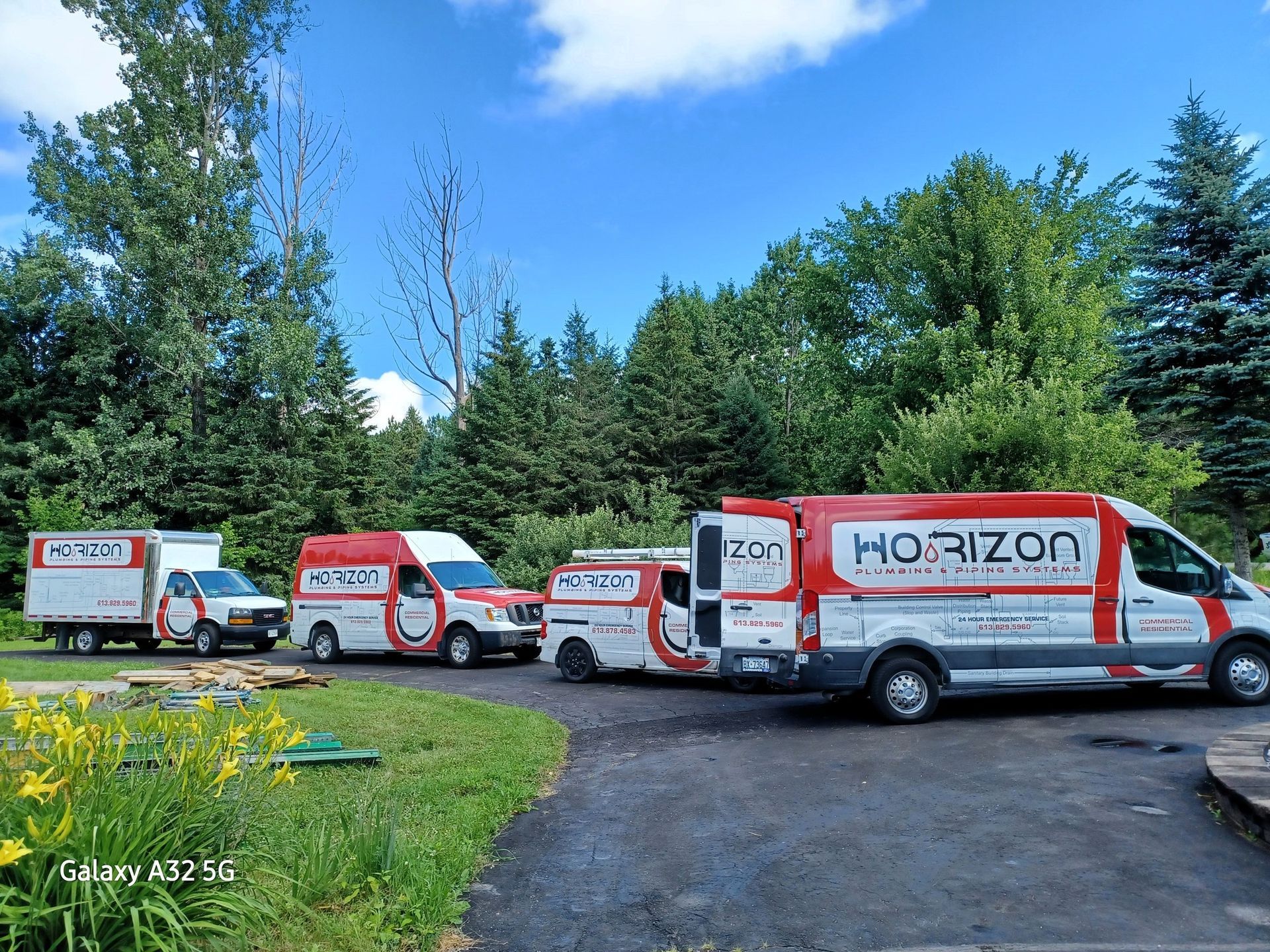 A row of horizon vans are parked in a driveway.