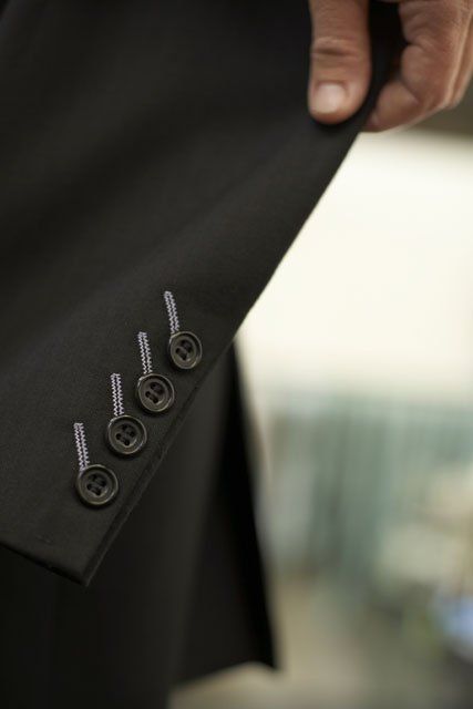 Angled stitching button holes light grey on black