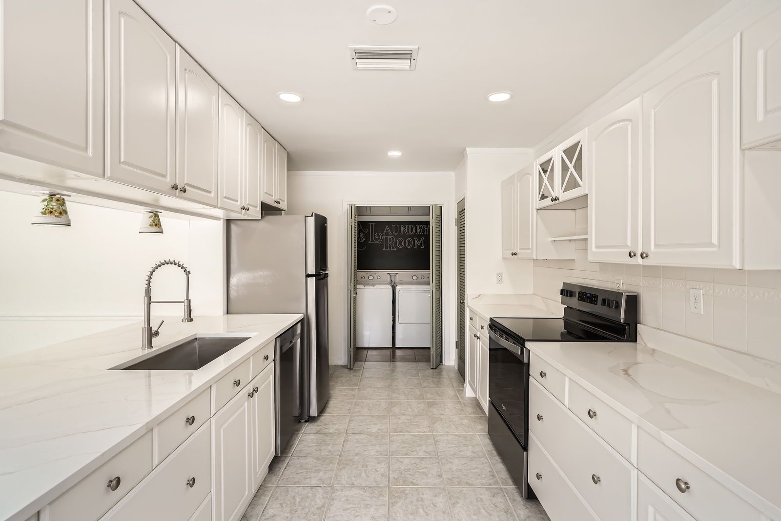 A kitchen with white cabinets and stainless steel appliances.