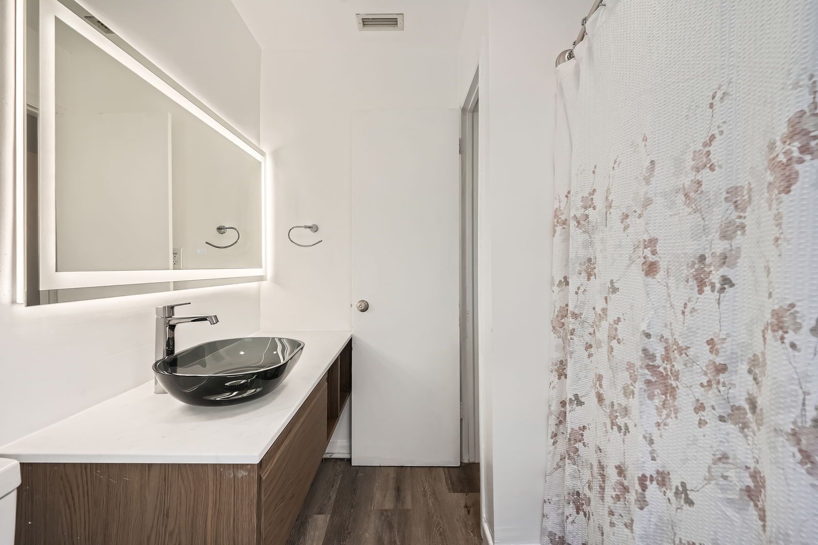 A bathroom with a sink , mirror and shower curtain.