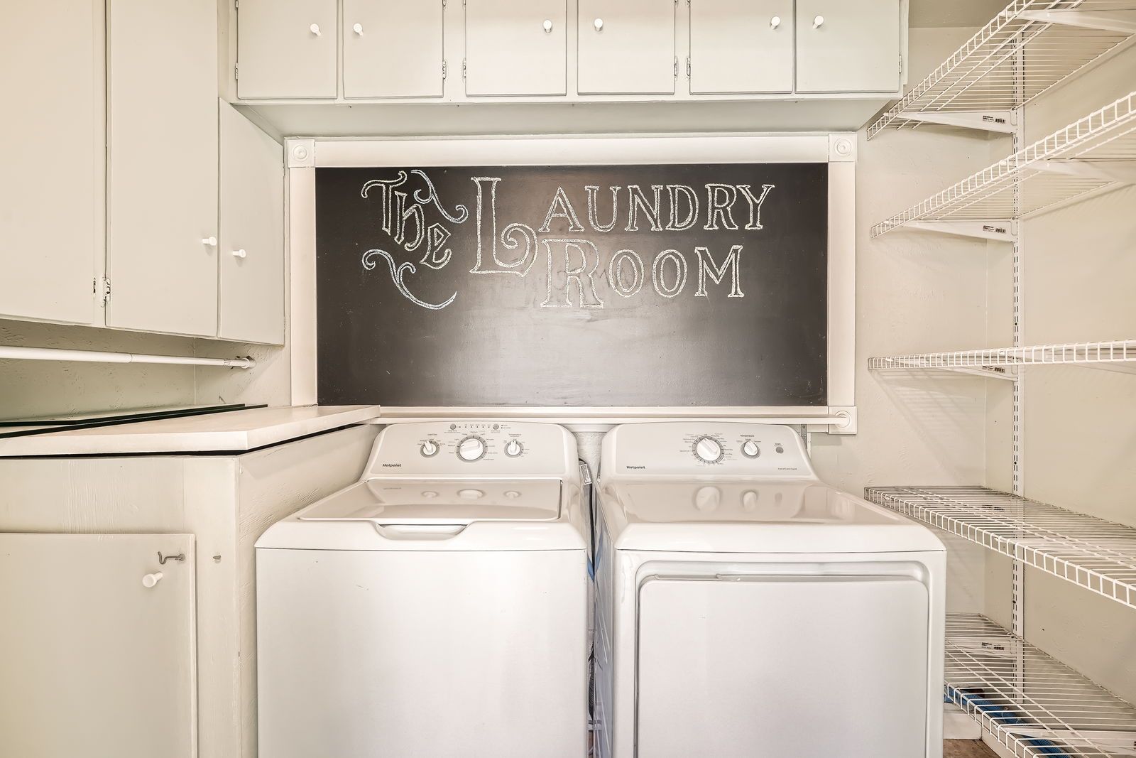 A laundry room with a chalkboard above the washer and dryer.