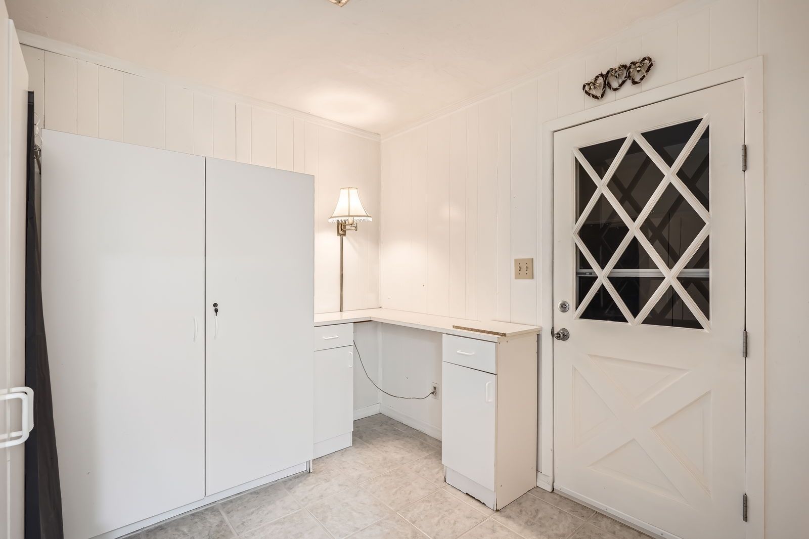 A white room with a door and a desk