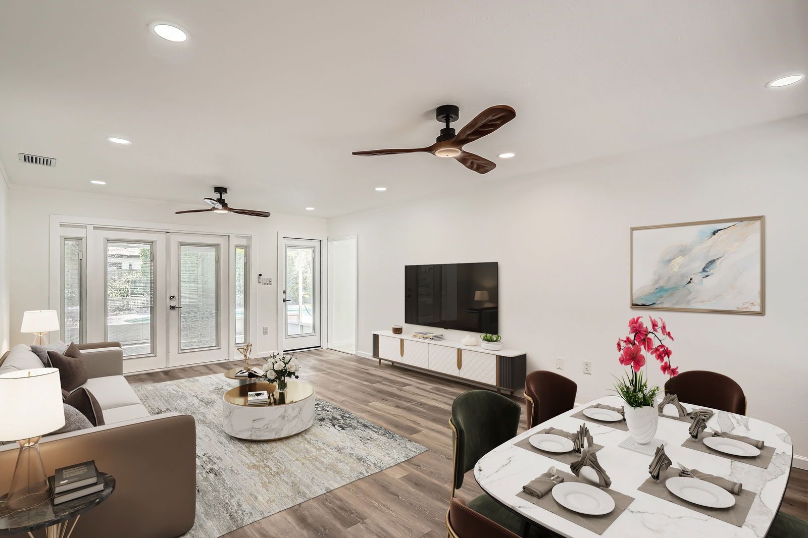 A living room with a table and chairs and a ceiling fan.