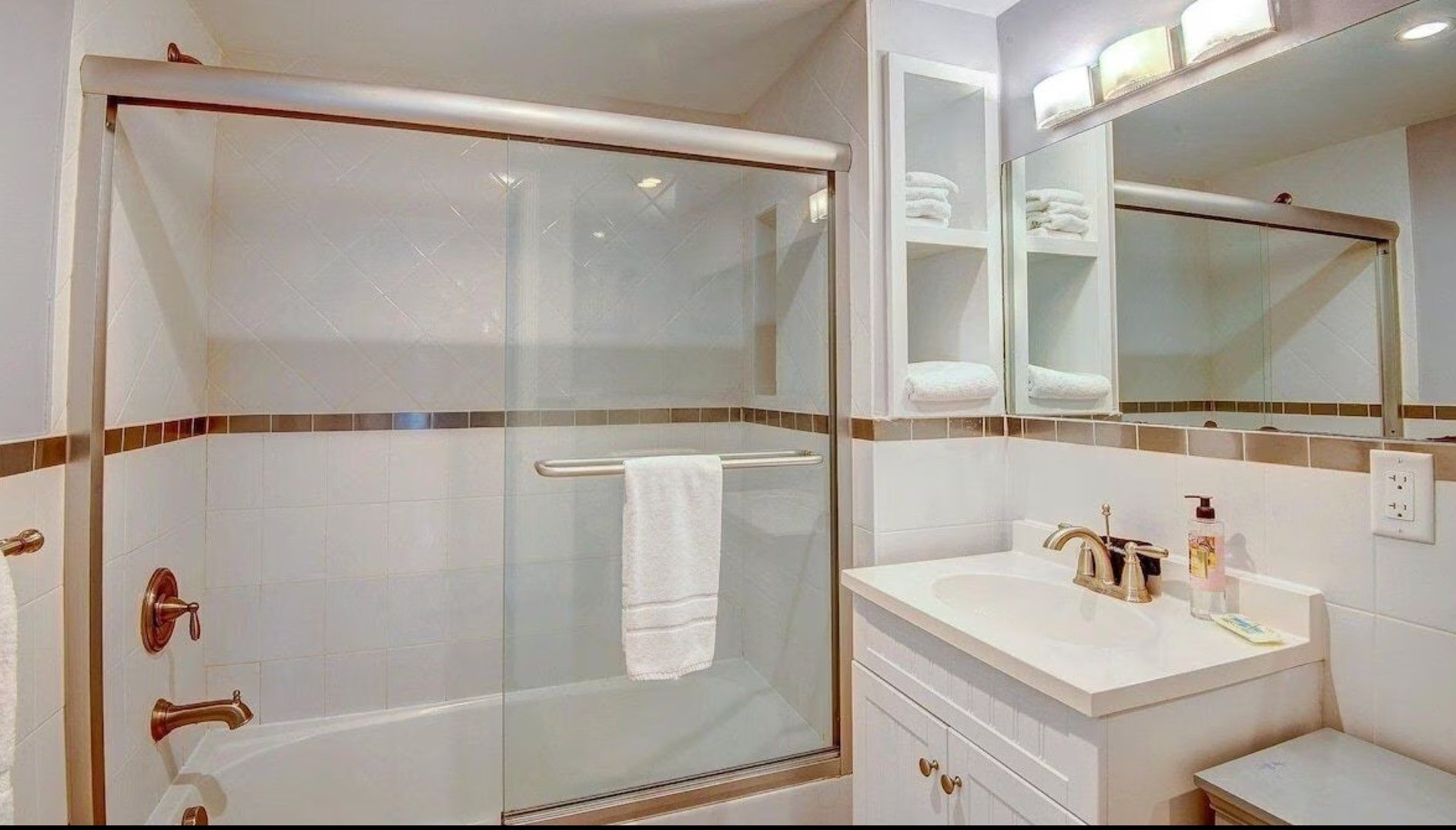 A bathroom with a sink , tub , shower and mirror