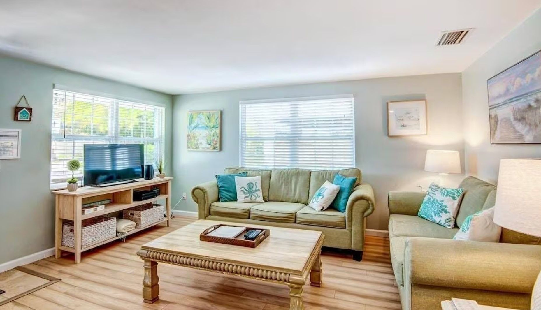 A living room with a couch , coffee table , and television.
