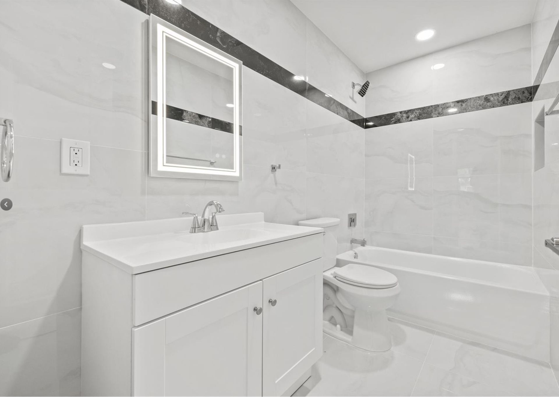 A bathroom with a sink , toilet , tub and mirror.