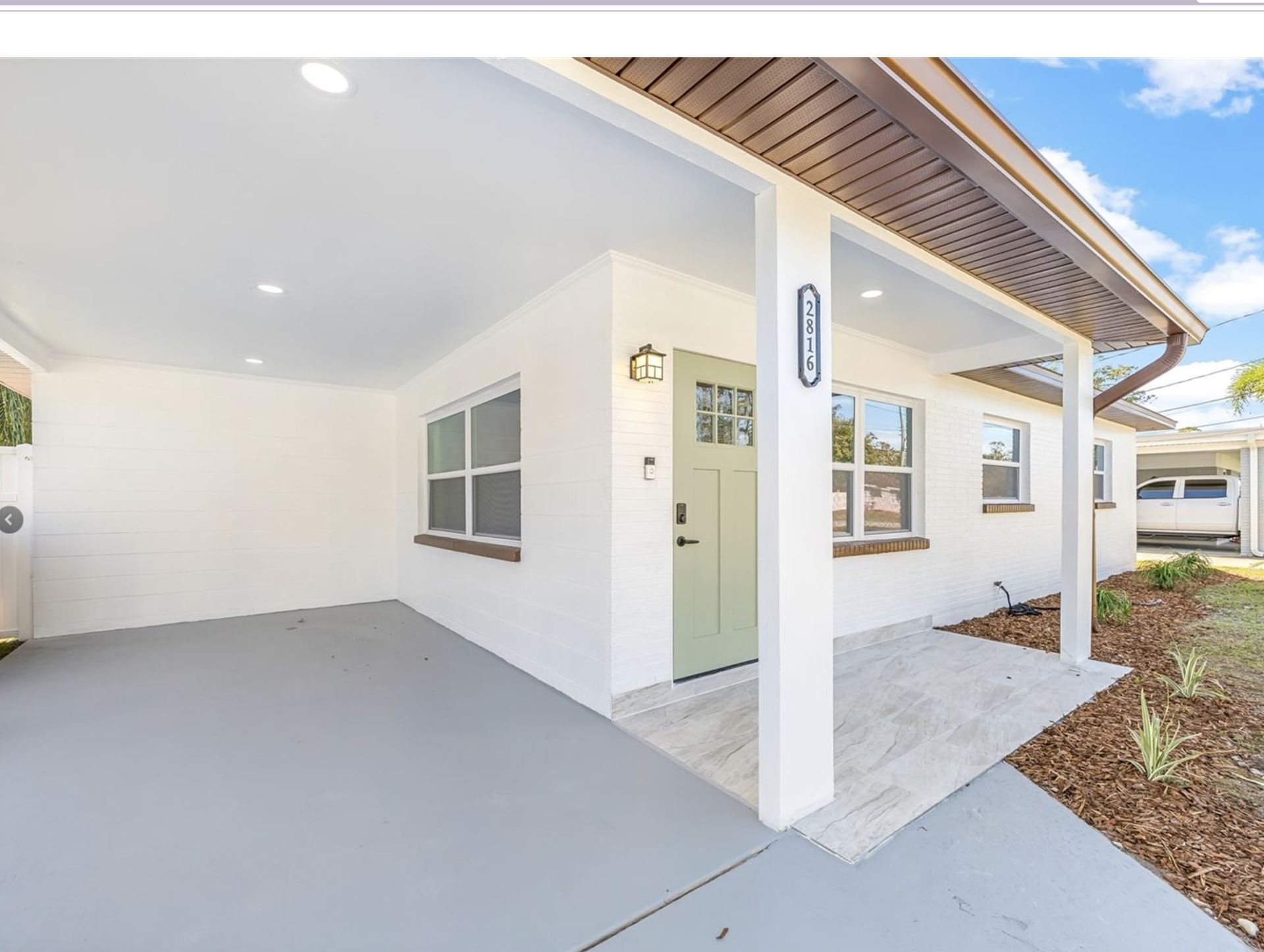 A white house with a green door and a porch