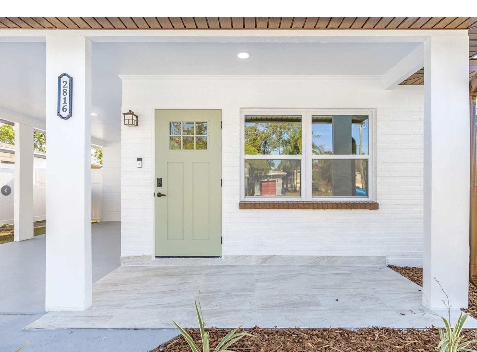 A white house with a green door and a window