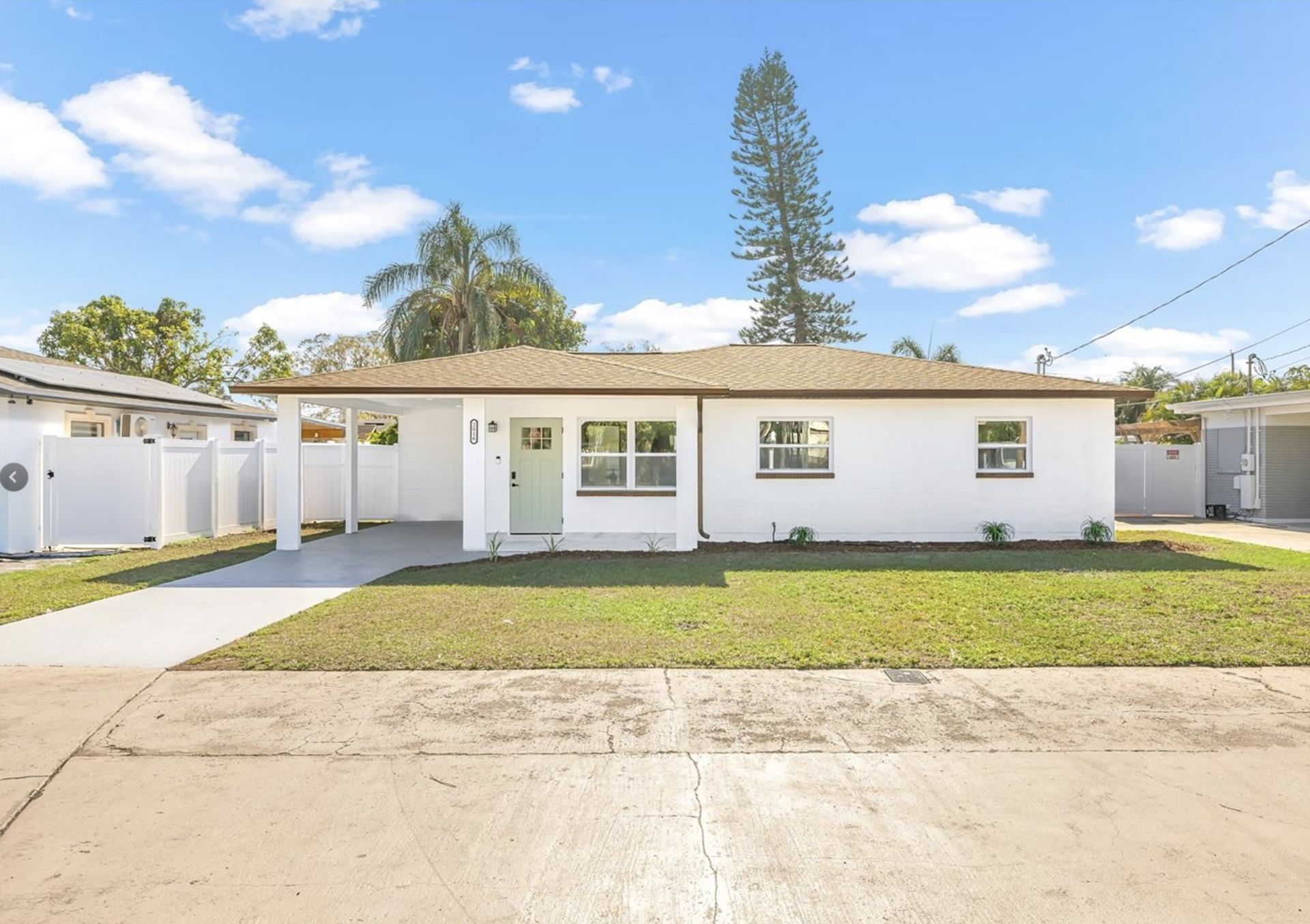 A white house with a brown roof is for sale