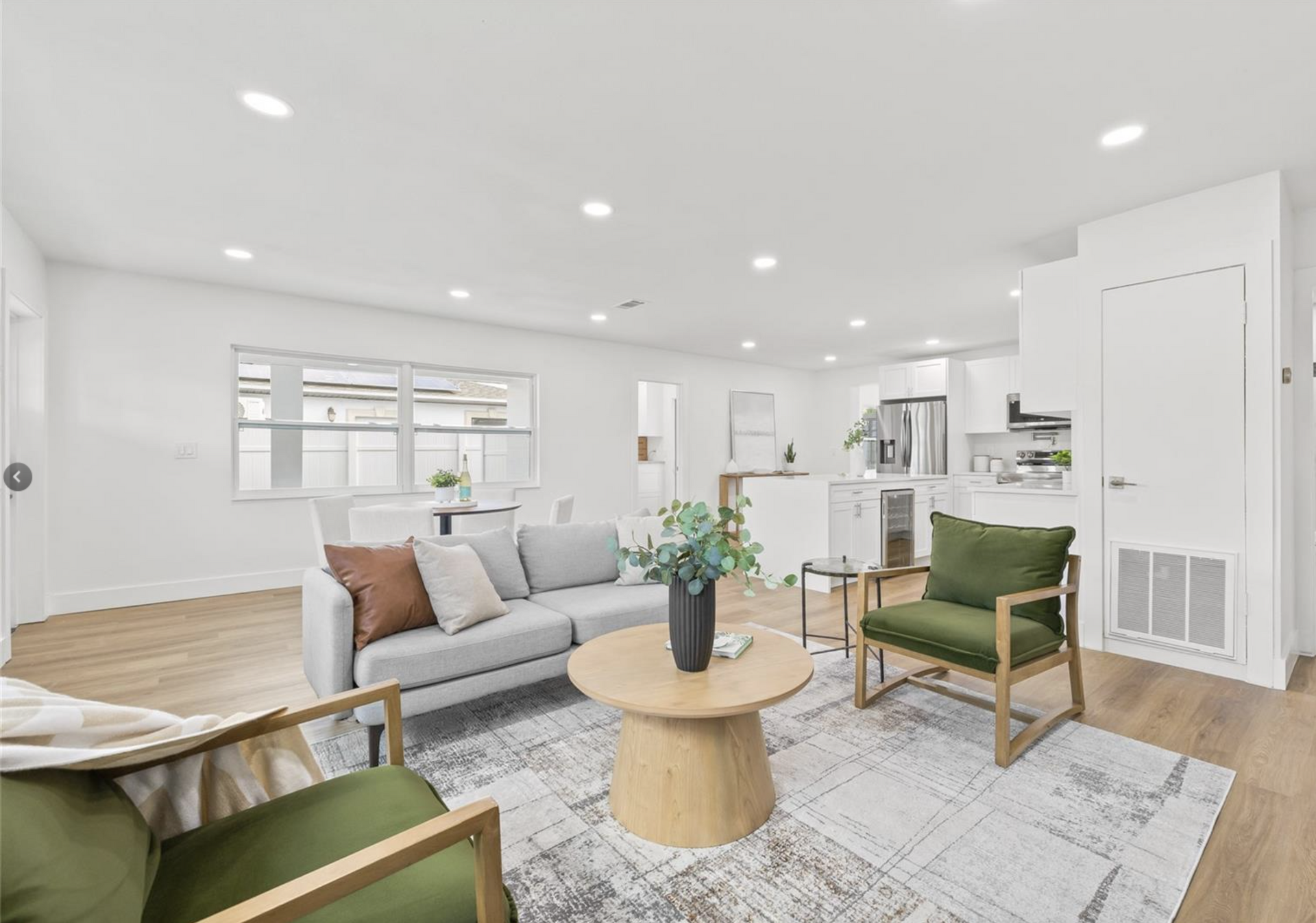 A living room with a couch , chairs , and a coffee table.