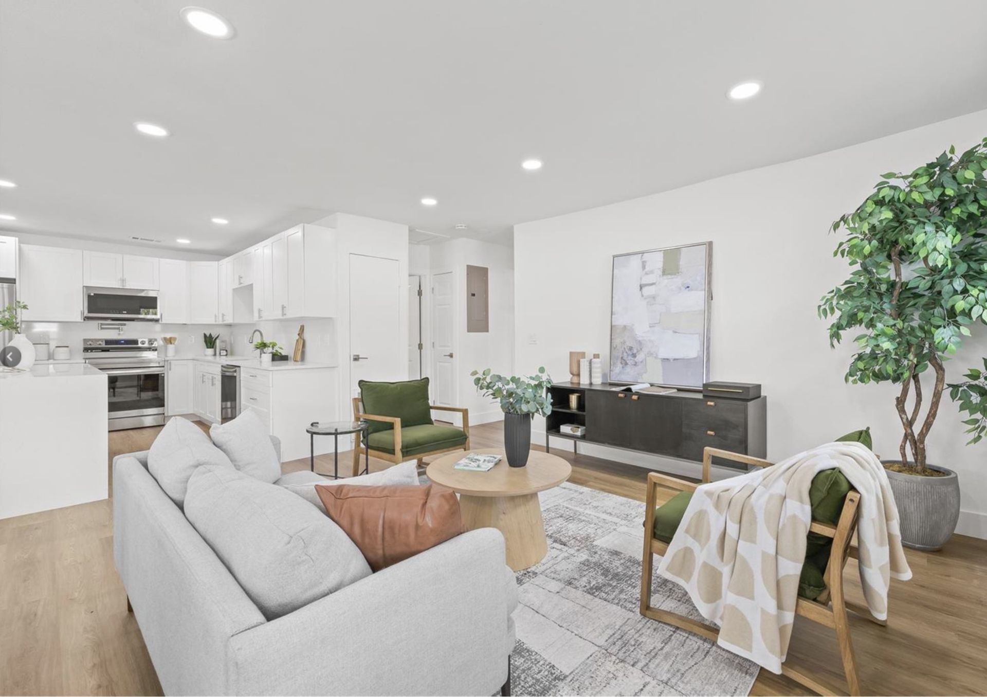 A living room with a couch , chairs , and a table.