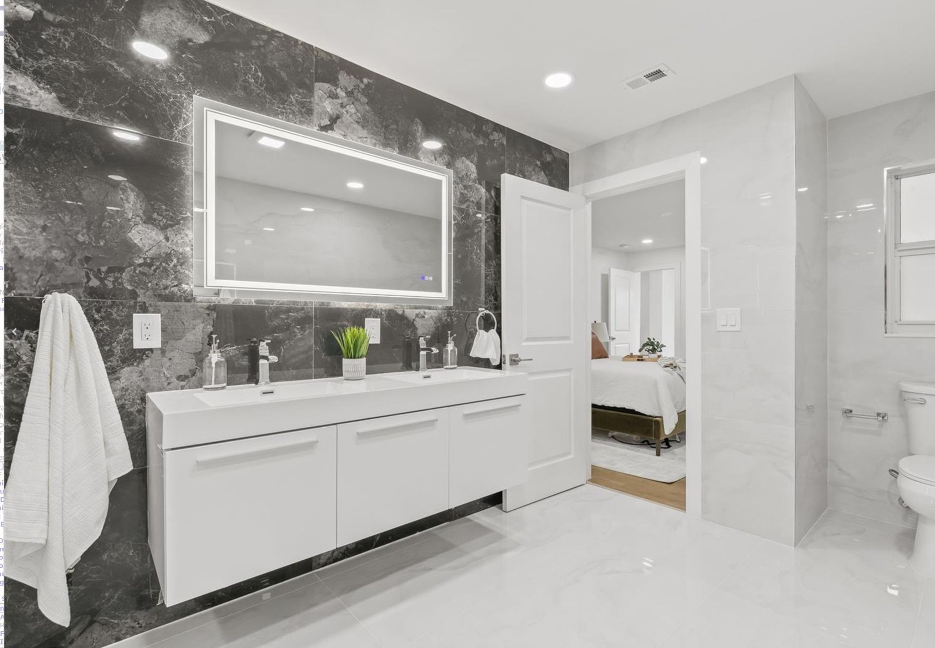 A bathroom with two sinks and a large mirror.
